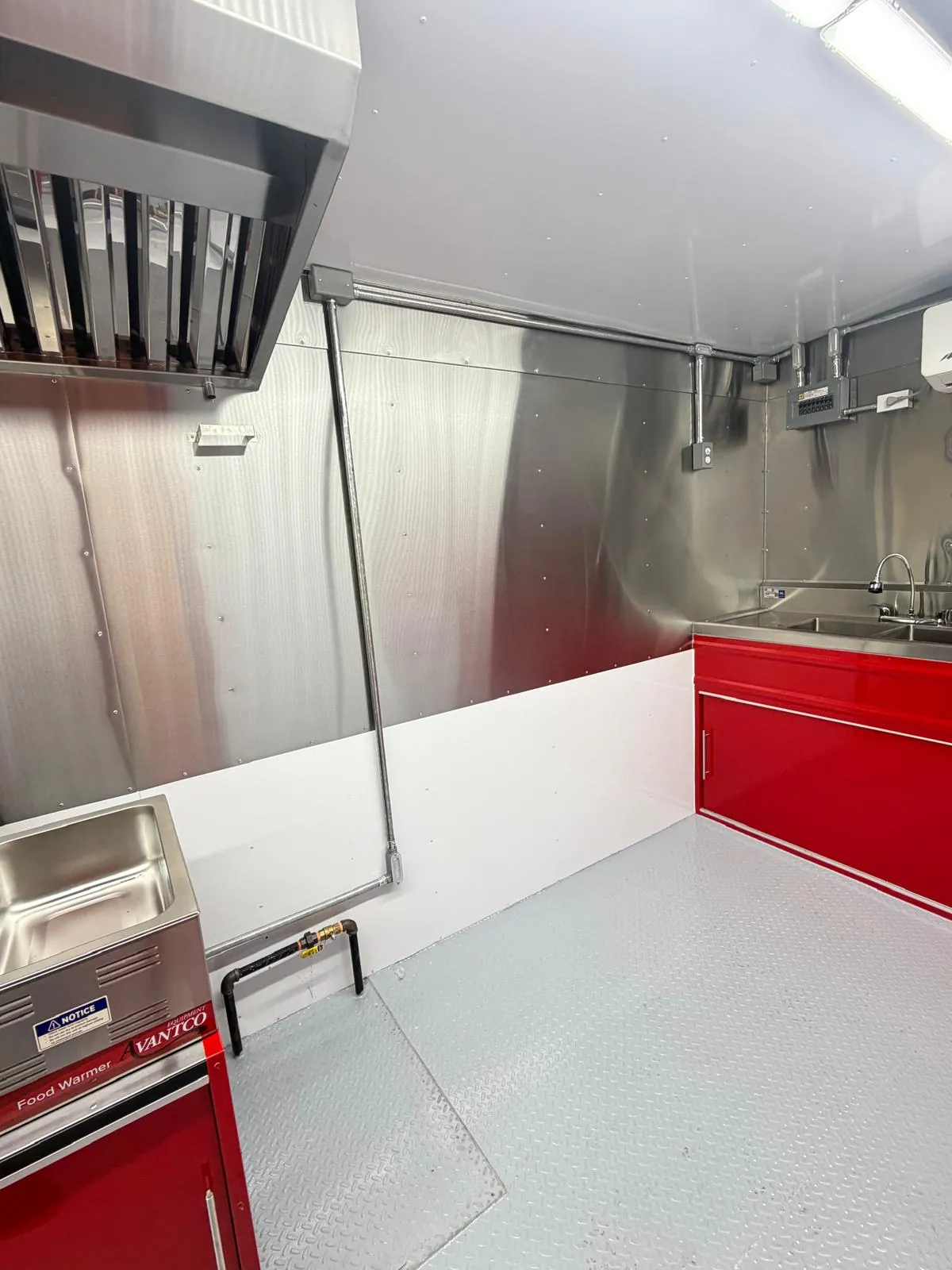 Interior de food trailer AMDA con campana de extracción, plancha y fregaderos